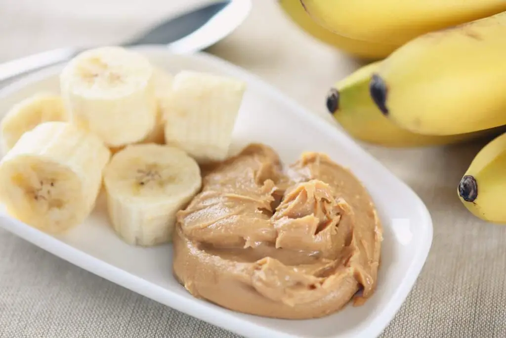 A plate with peanut butter and banana slices on it.
